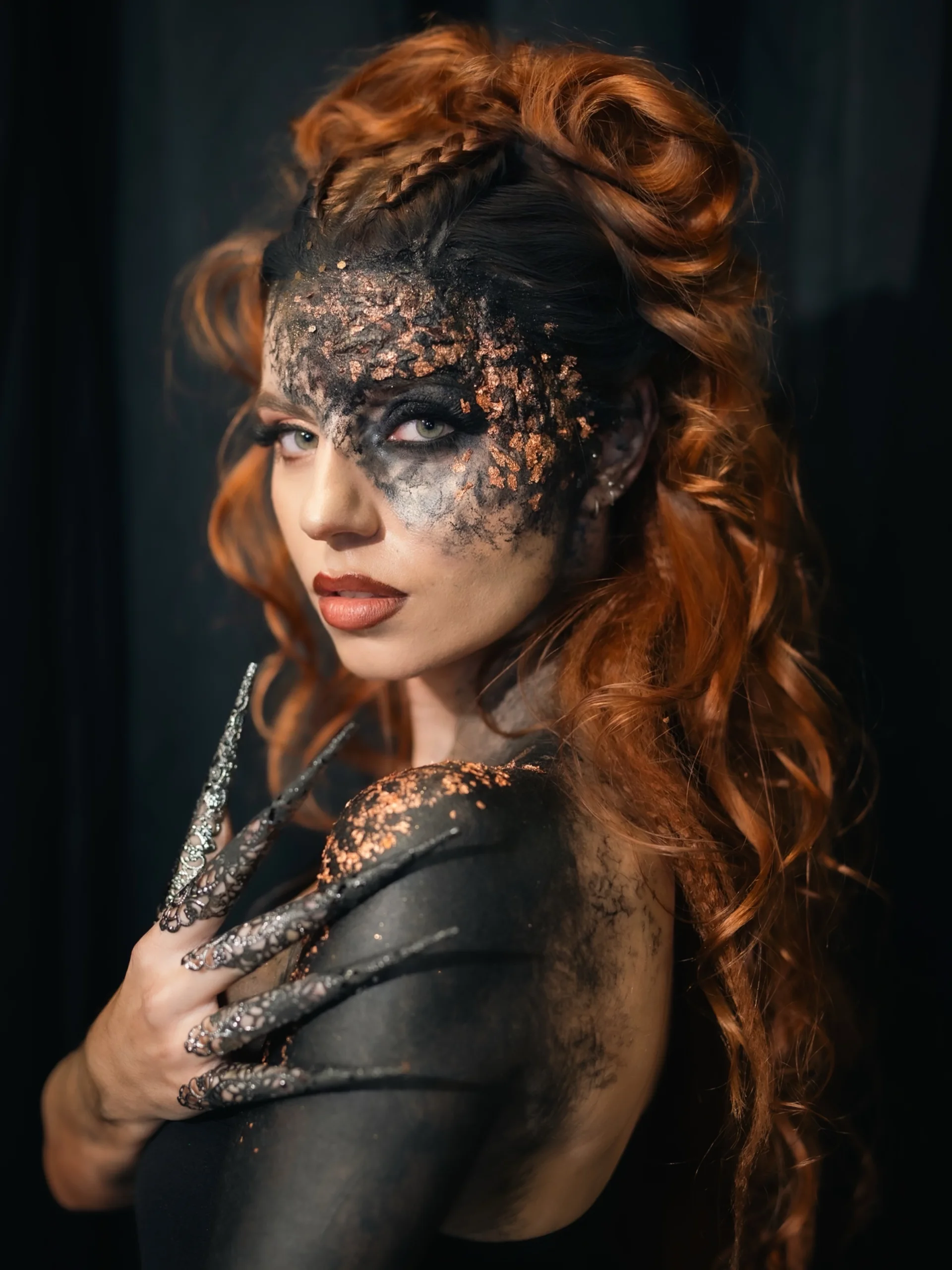 Marine, longue chevelure rousse bouclée et maquillage noir et doré, portrait en studio