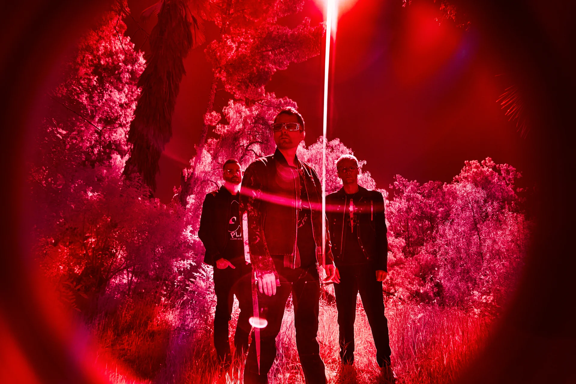 Muse dans une forêt baignée de lumière rouge, un faisceau lumineux tombant du ciel
