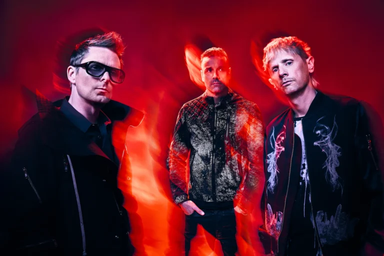 Matt Bellamy, Dominic Howard et Chris Wolstenholme, les trois membres de Muse, dans une lumière rouge
