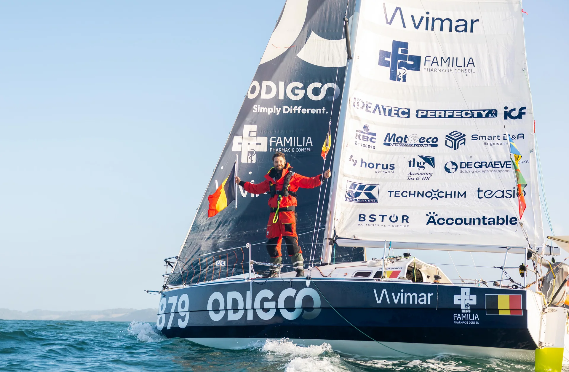 Quentin Debois brandit le drapeau belge à bord de son voilier, au large des côtes anglaises