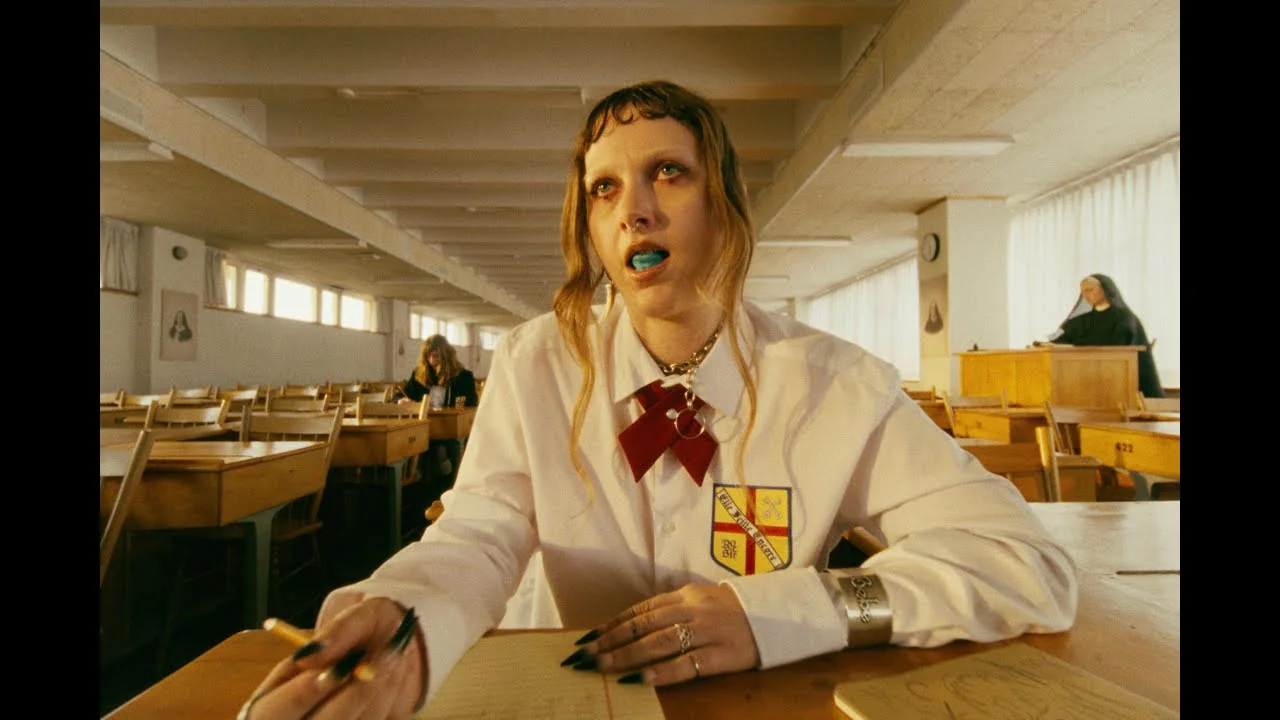 Image du clip n’as-tu jamais vu d’oiseaux ? de Rosier : une élève en chemise blanche et nœud rouge dans une salle d’étude