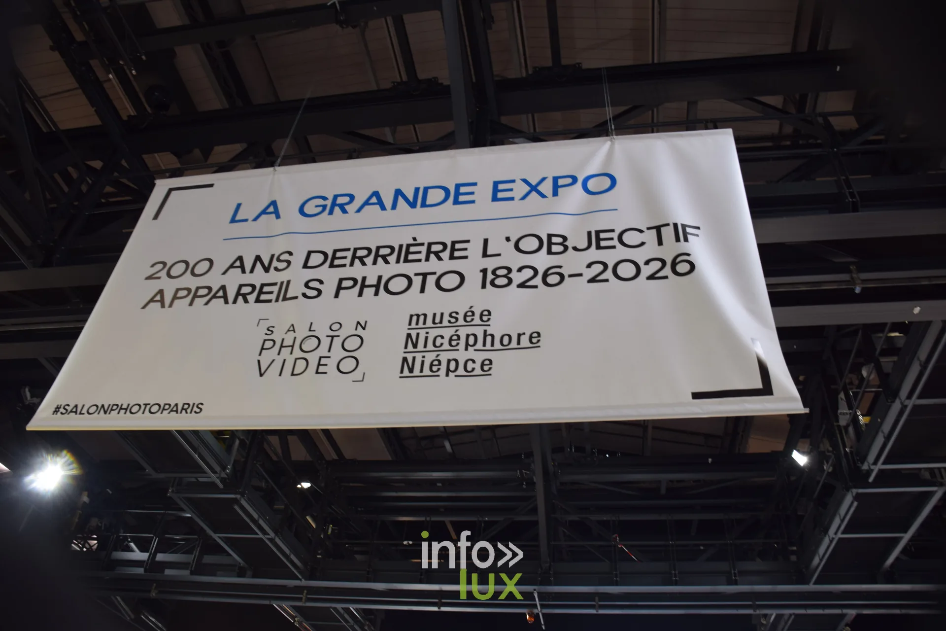 Salon Photo & Vidéo 2026, Grande Halle de la Villette, Paris : La bannière de la Grande Expo « 200 ans derrière l’objectif », appareils photo 1826-2026, avec le musée Nicéphore Niépce