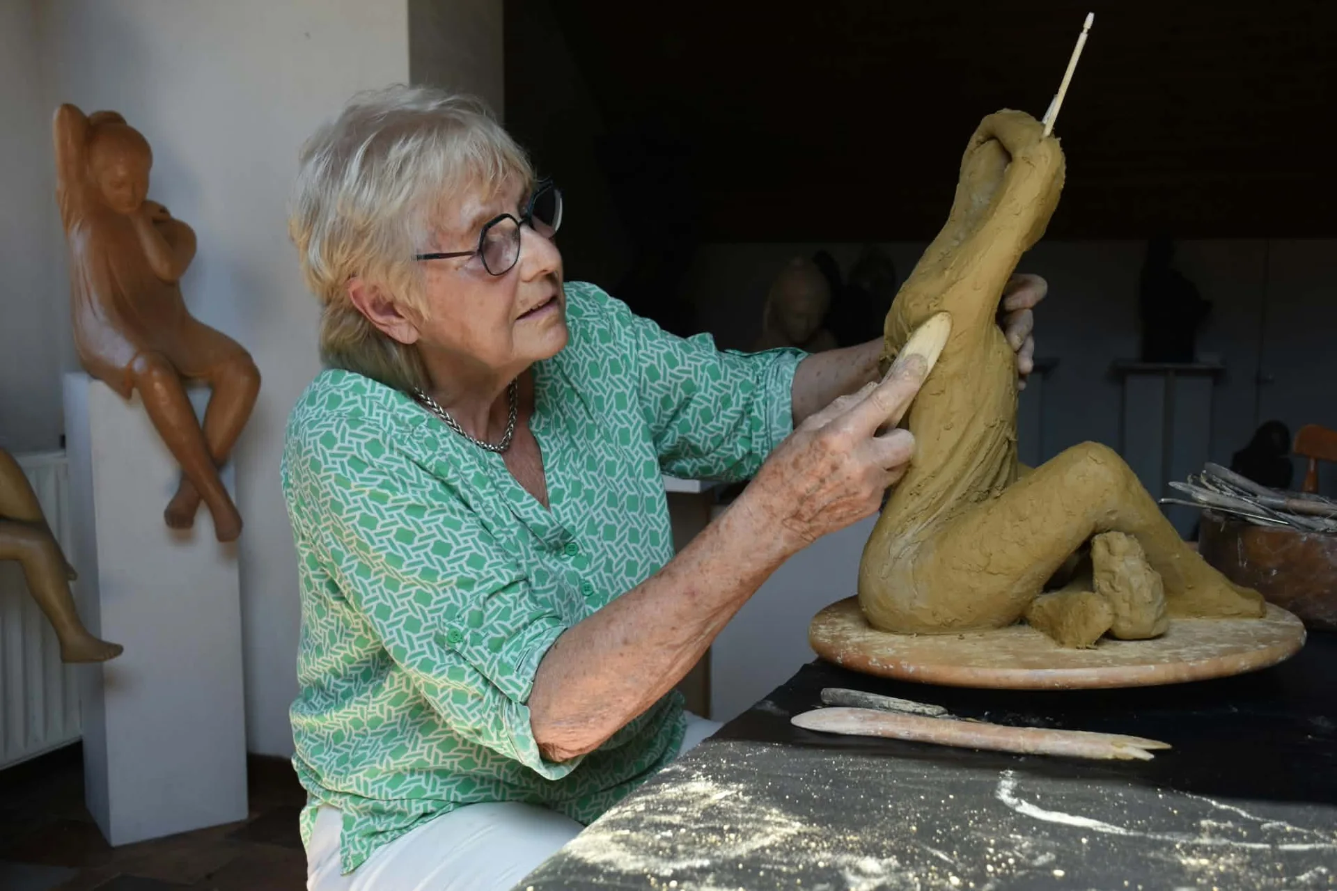 Ursula Förster modelant une sculpture en terre dans son atelier