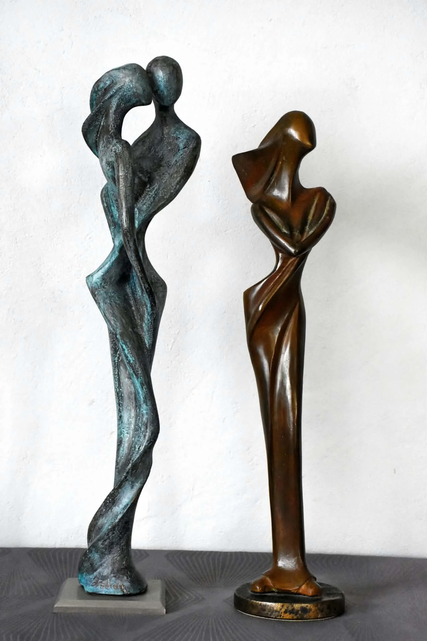 Deux sculptures élancées en bronze patiné, silhouettes de couples