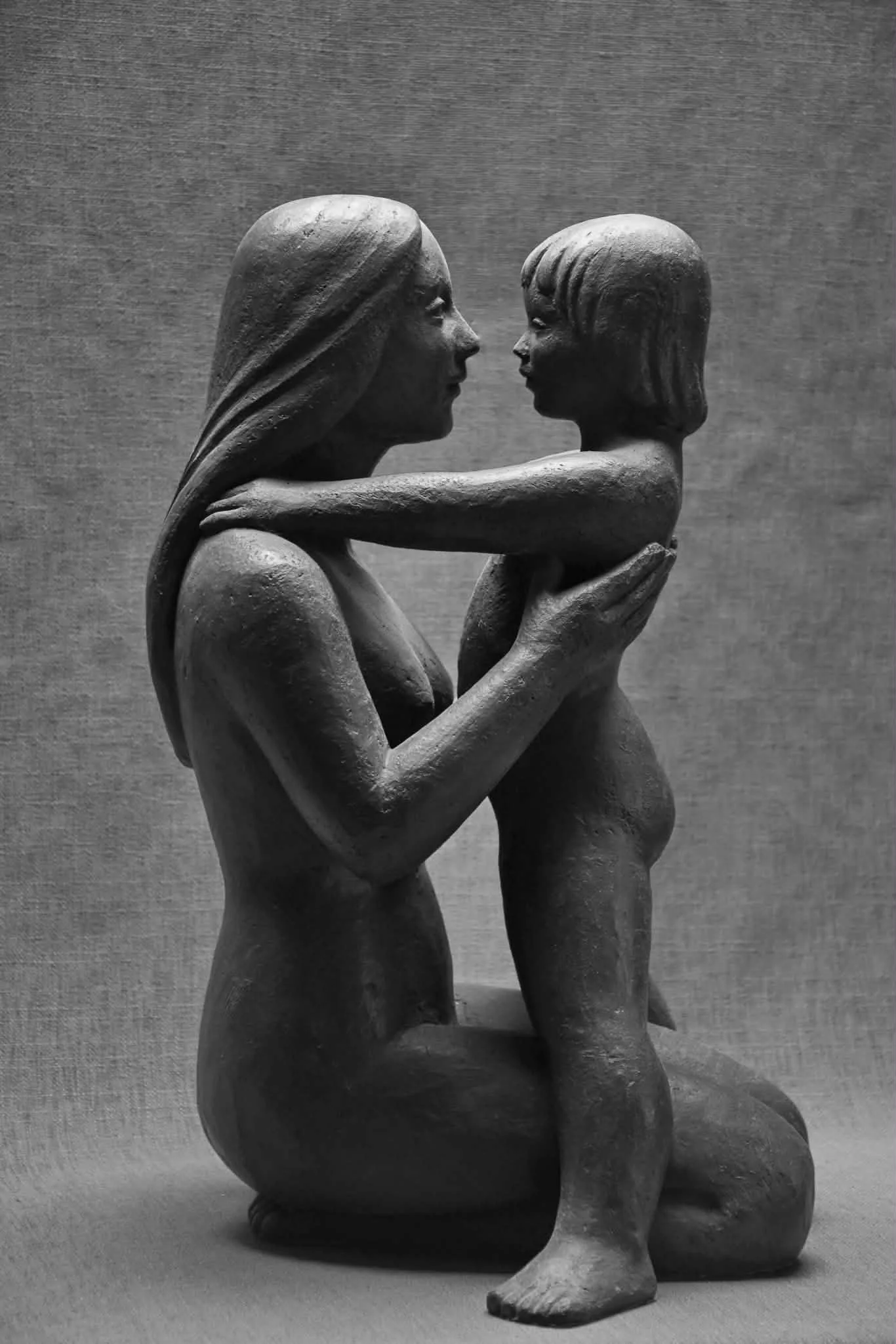 Sculpture d’un couple face à face, en terre sombre