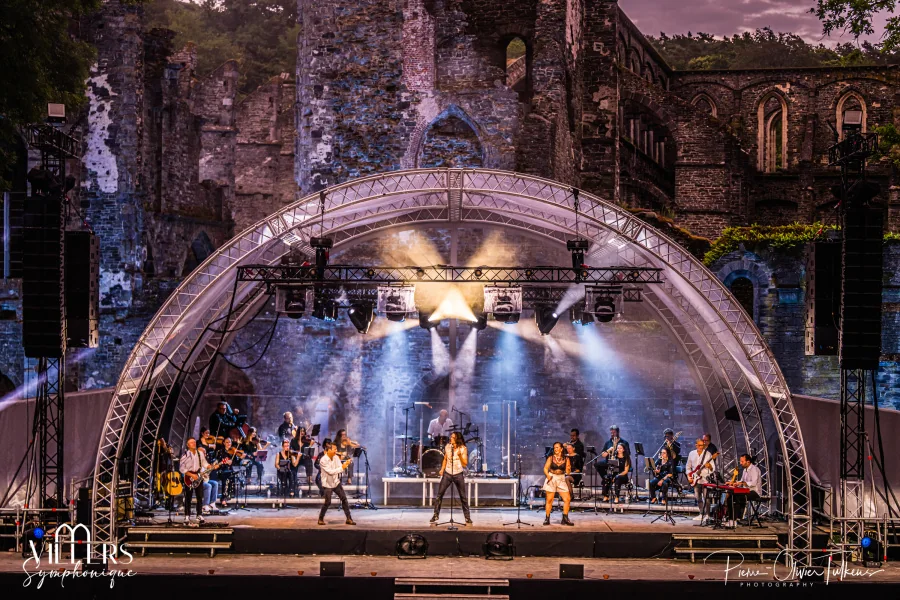 Concert de Villers Symphonique : orchestre et chanteurs sur la scène en arche dressée devant les ruines de l’abbaye de Villers-la-Ville