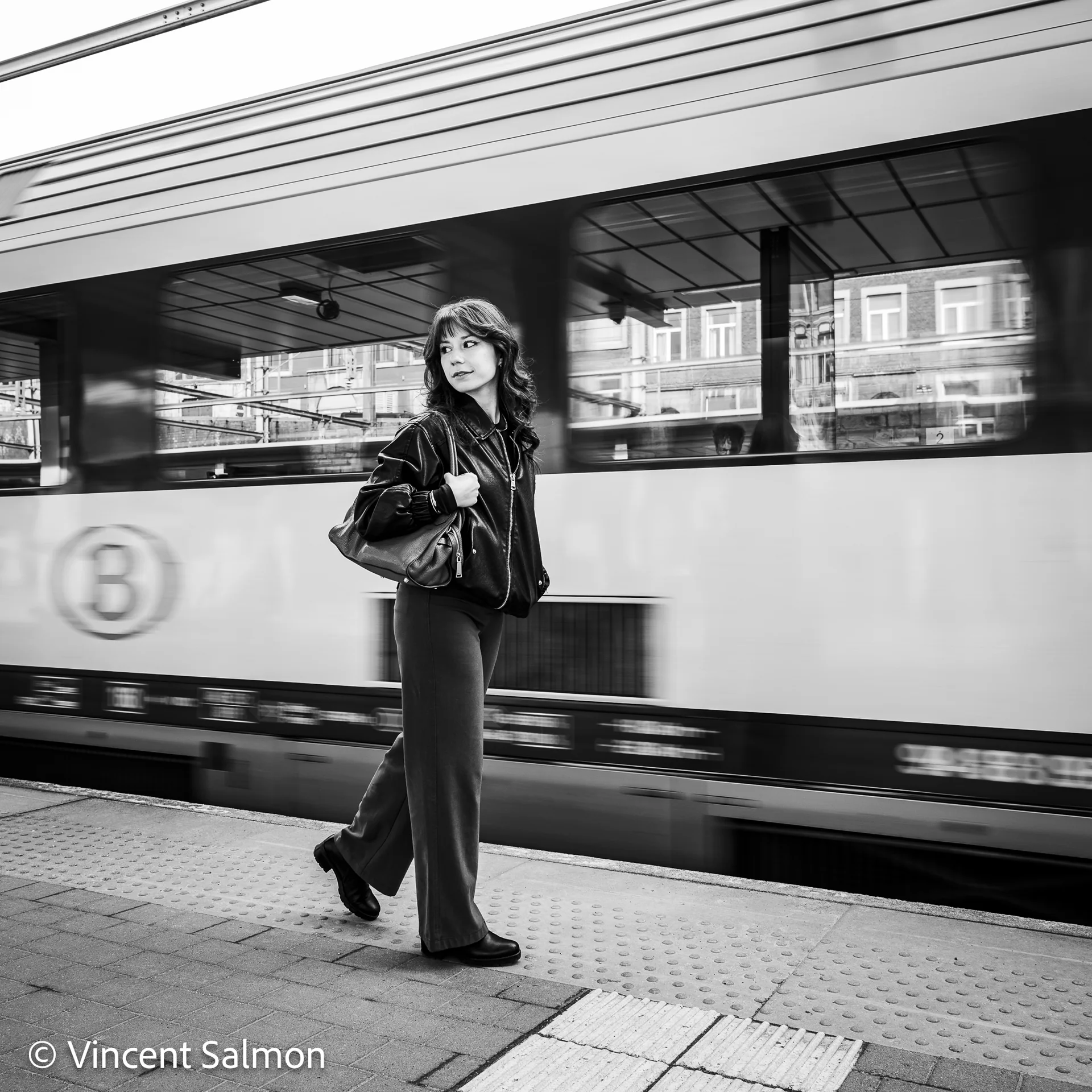 Photo de Vincent Salmon : une femme marche sur un quai de gare devant un train