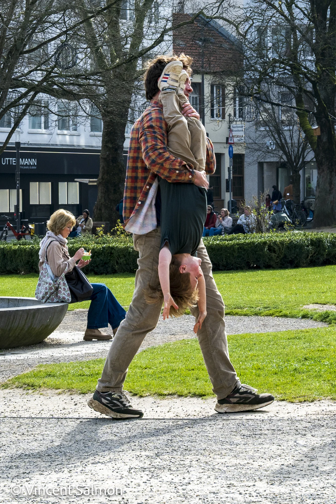 Photo de Vincent Salmon : un homme porte une enfant tête en bas dans un parc