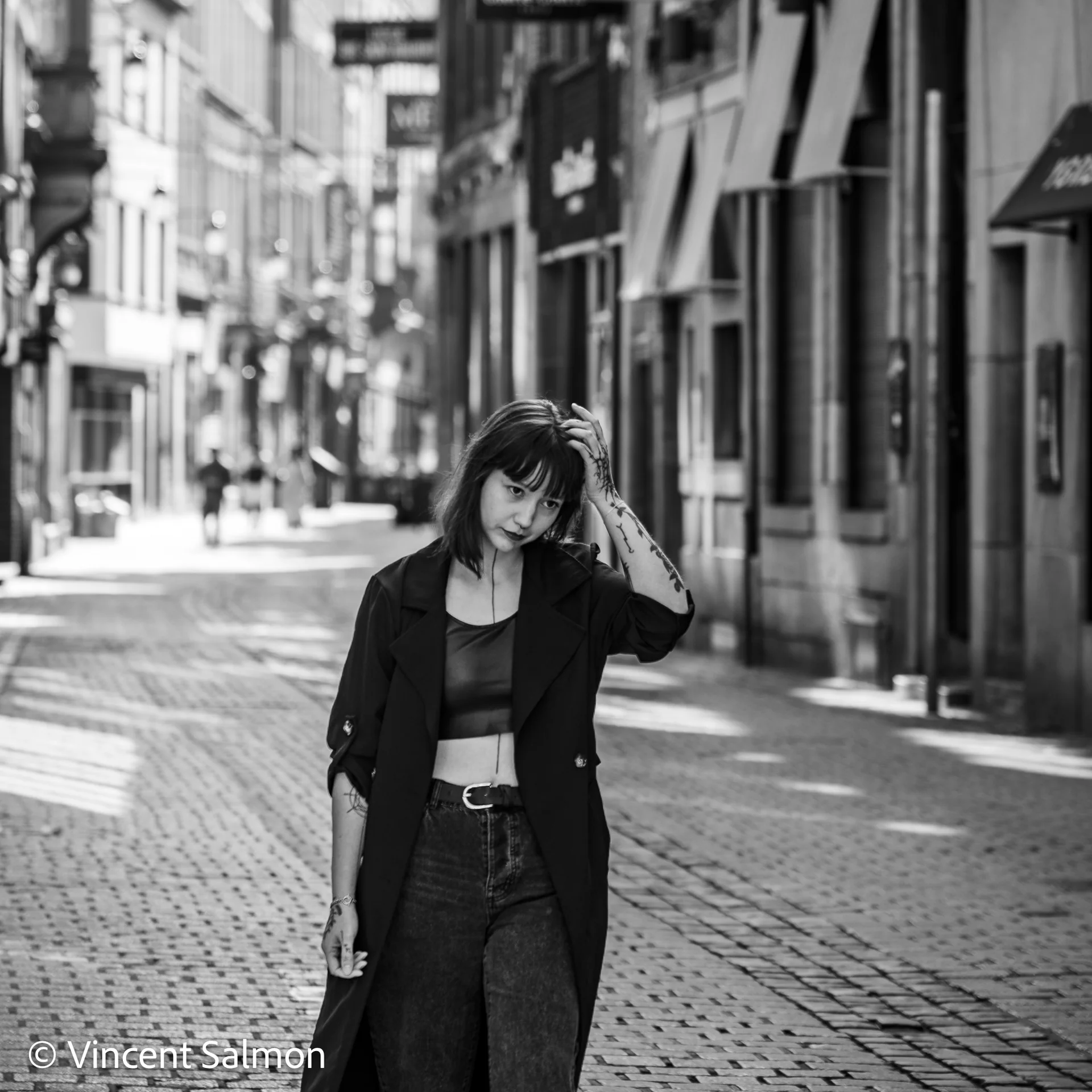 Photo de Vincent Salmon : une jeune femme dans une rue commerçante, en noir et blanc