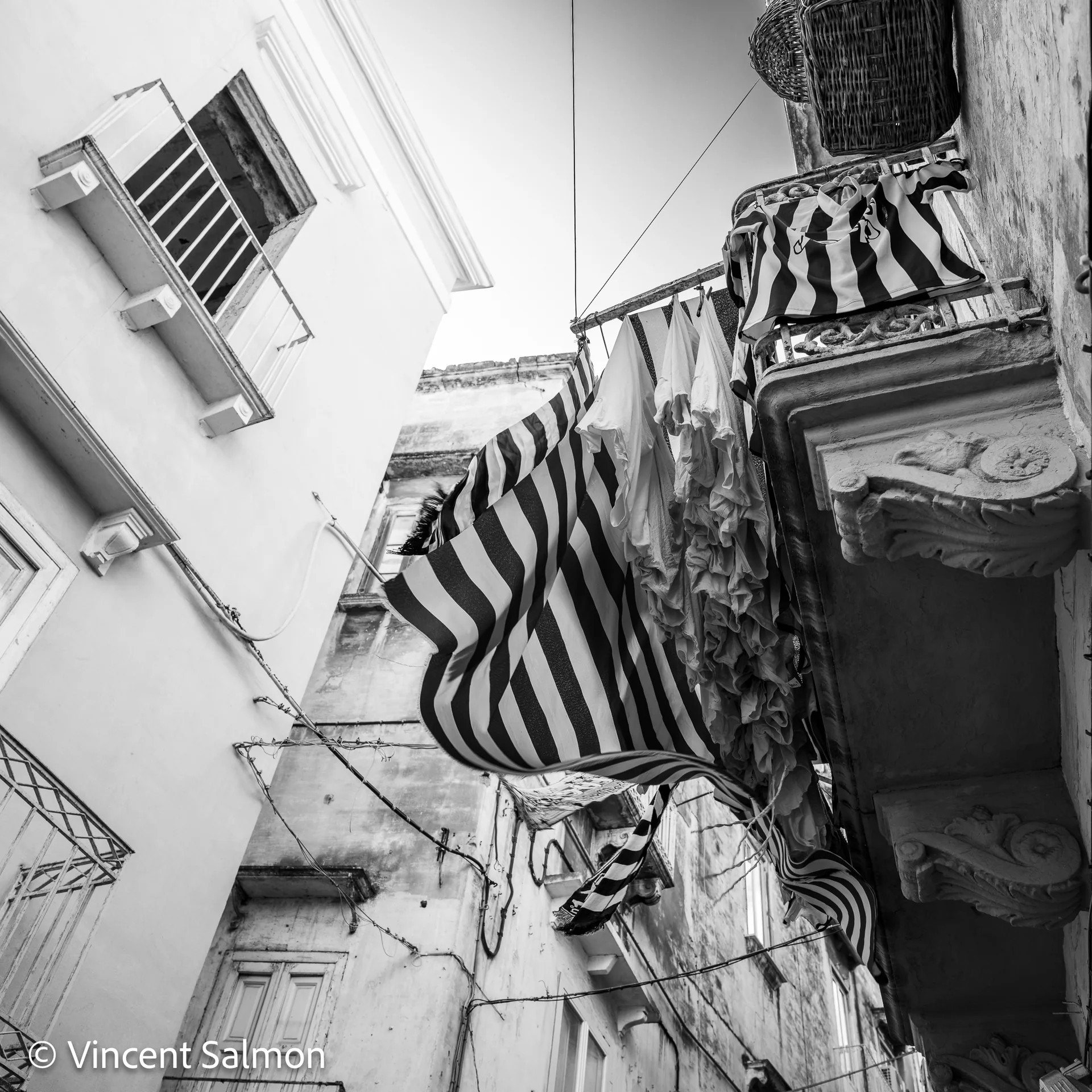 Photo de Vincent Salmon : des stores rayés et un balcon vus en contre-plongée
