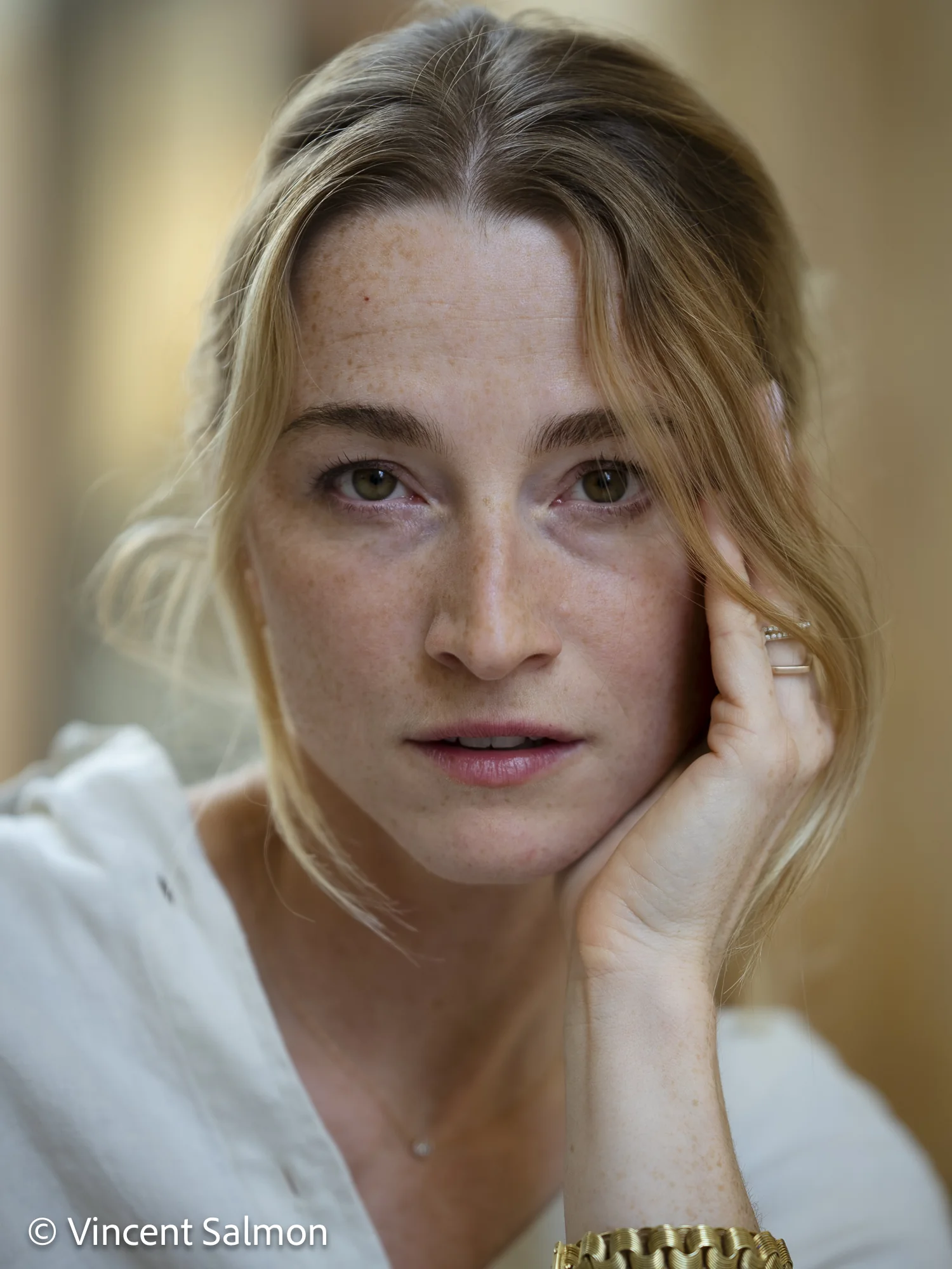 Photo de Vincent Salmon : portrait couleur d’une femme, la main sur la joue