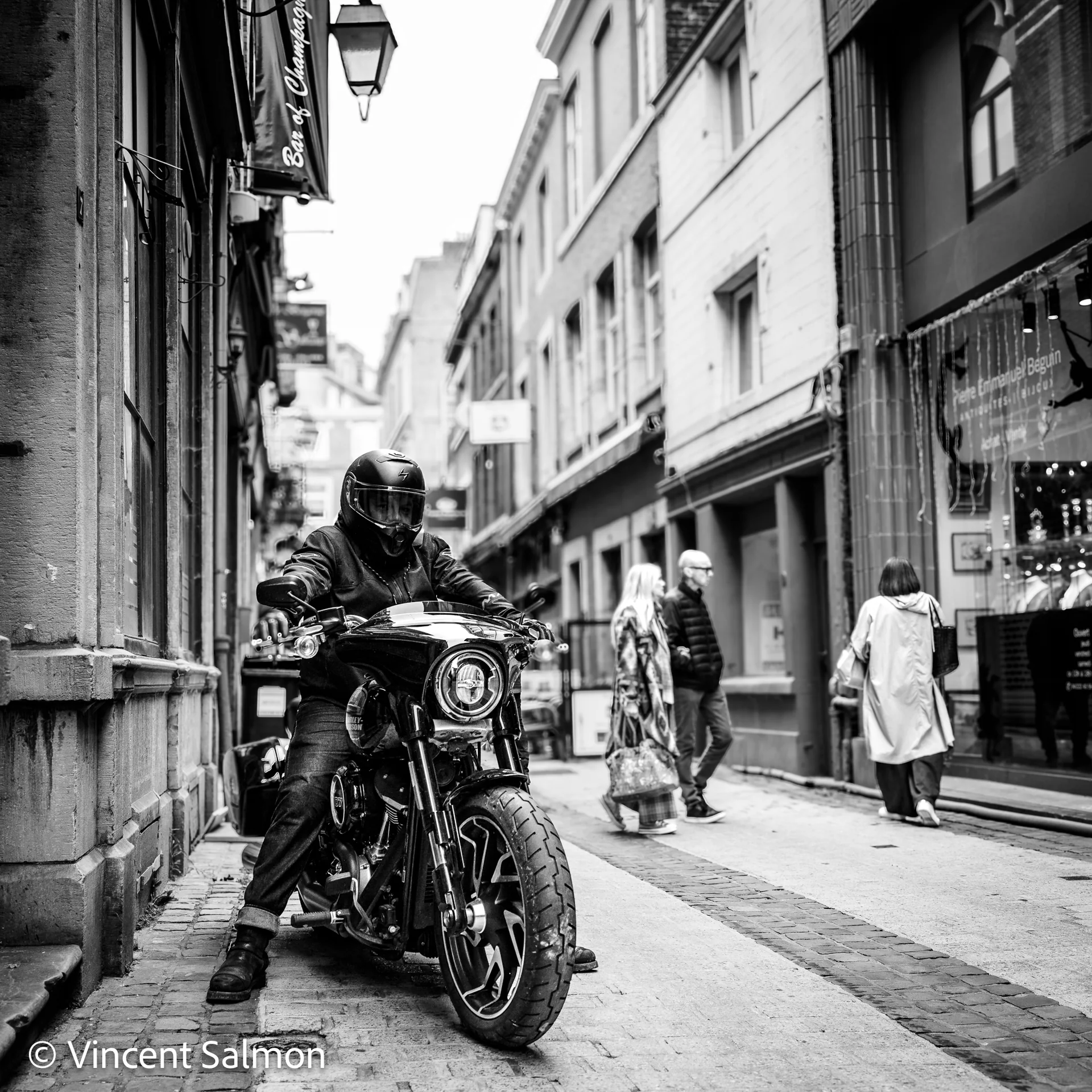 Photo de Vincent Salmon : un motard dans une rue commerçante