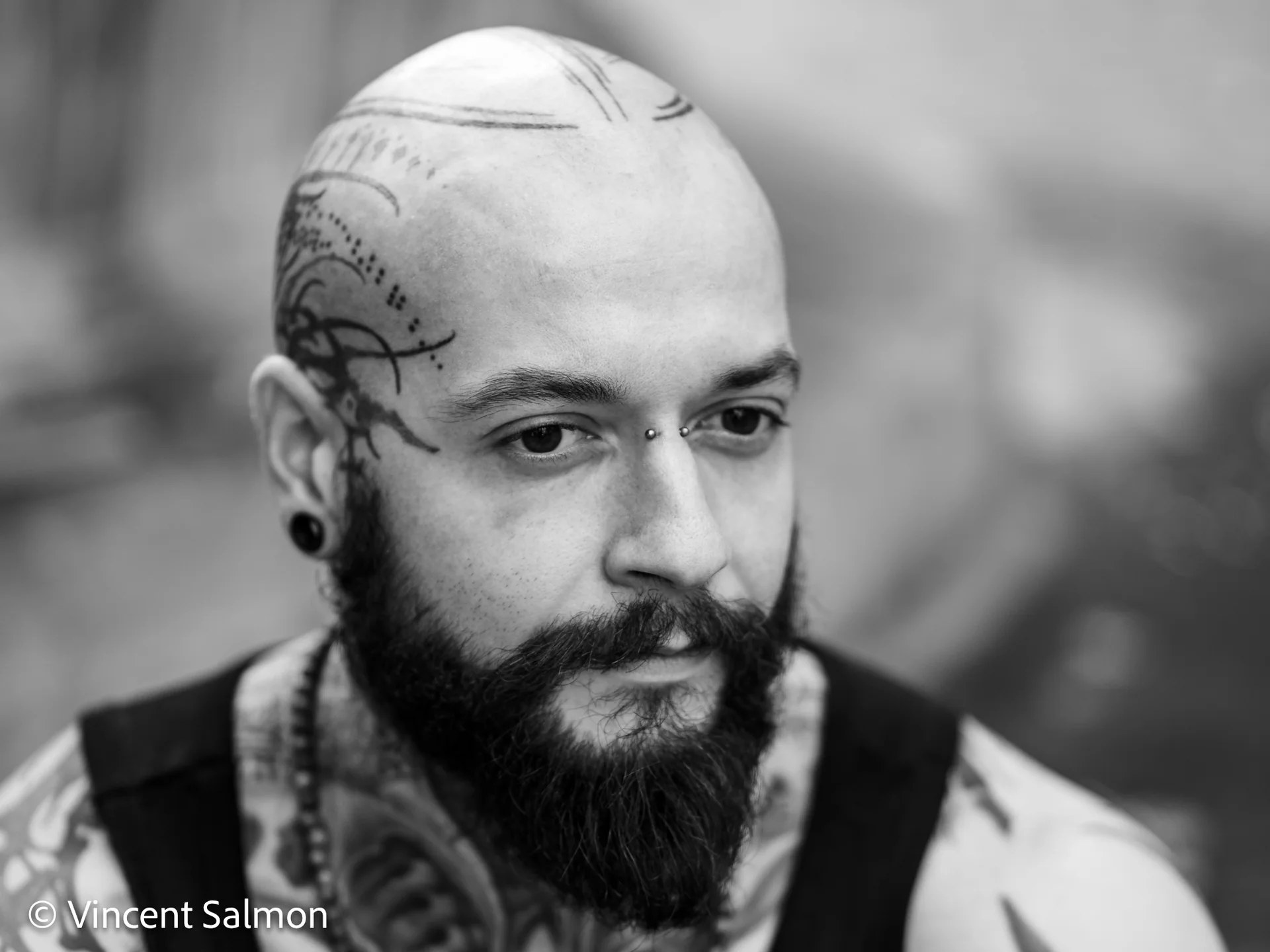 Photo de Vincent Salmon : portrait d’un homme barbu au crâne tatoué