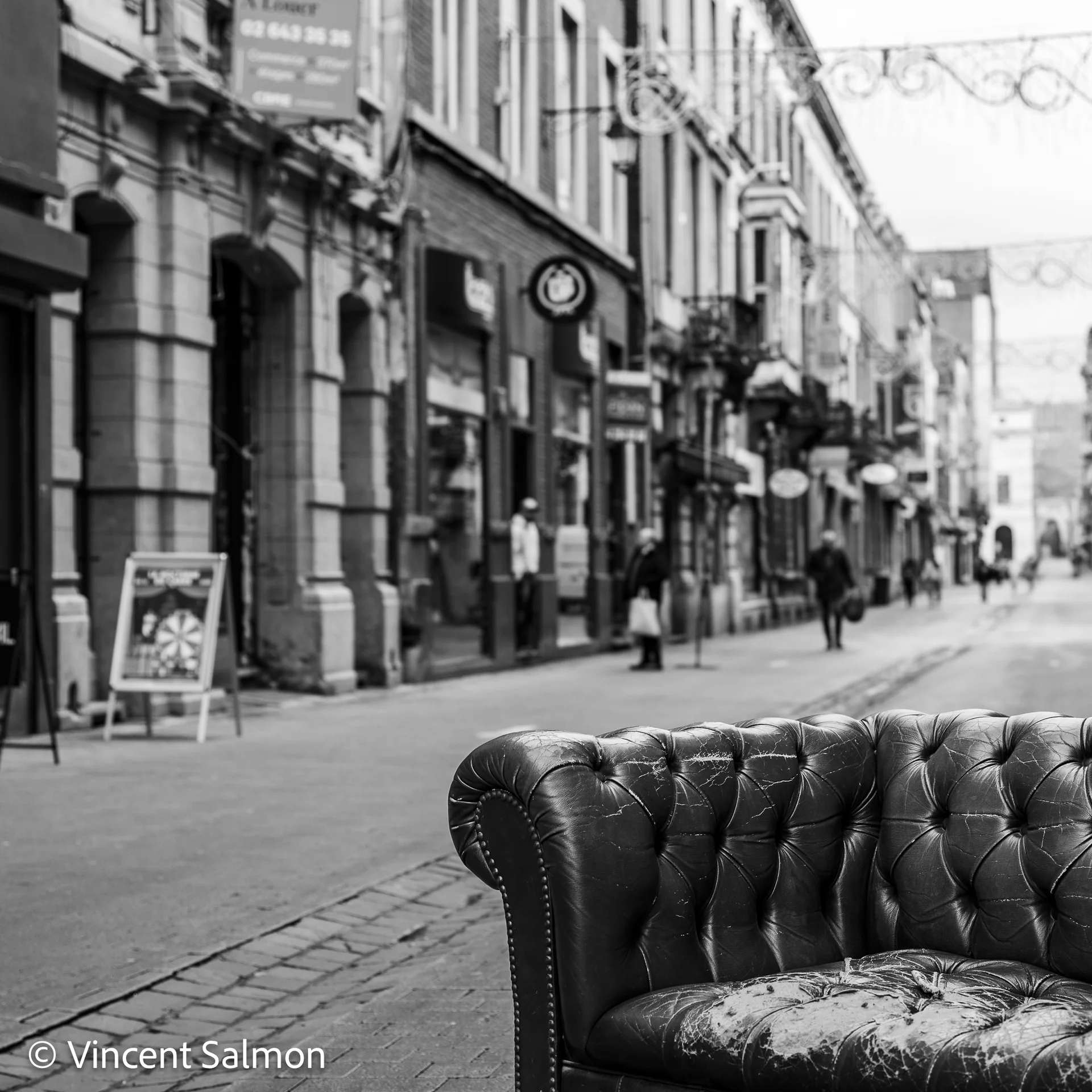 Photo de Vincent Salmon : un fauteuil Chesterfield abandonné dans une rue commerçante