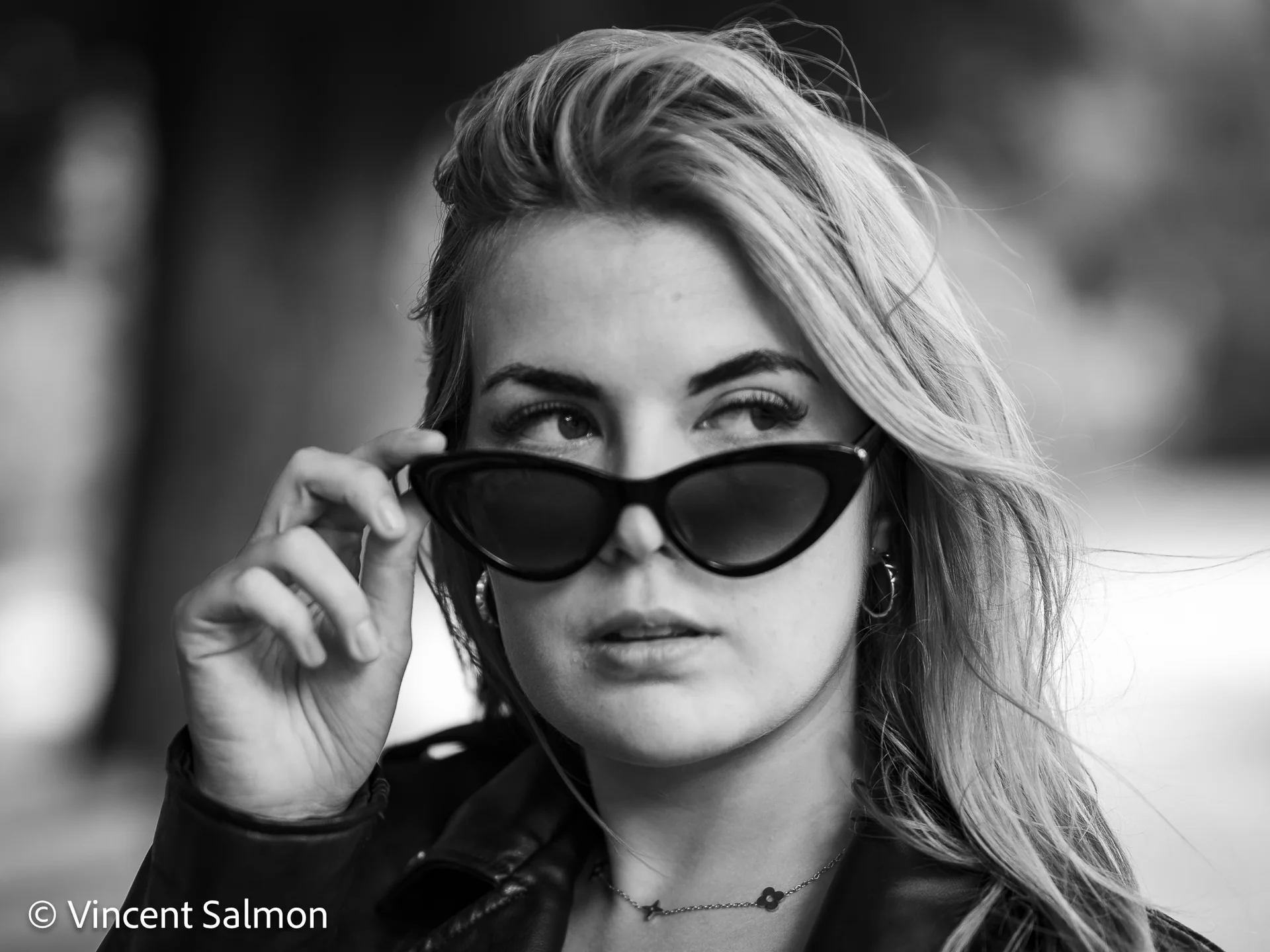 Photo de Vincent Salmon : une femme baisse ses lunettes de soleil, en noir et blanc