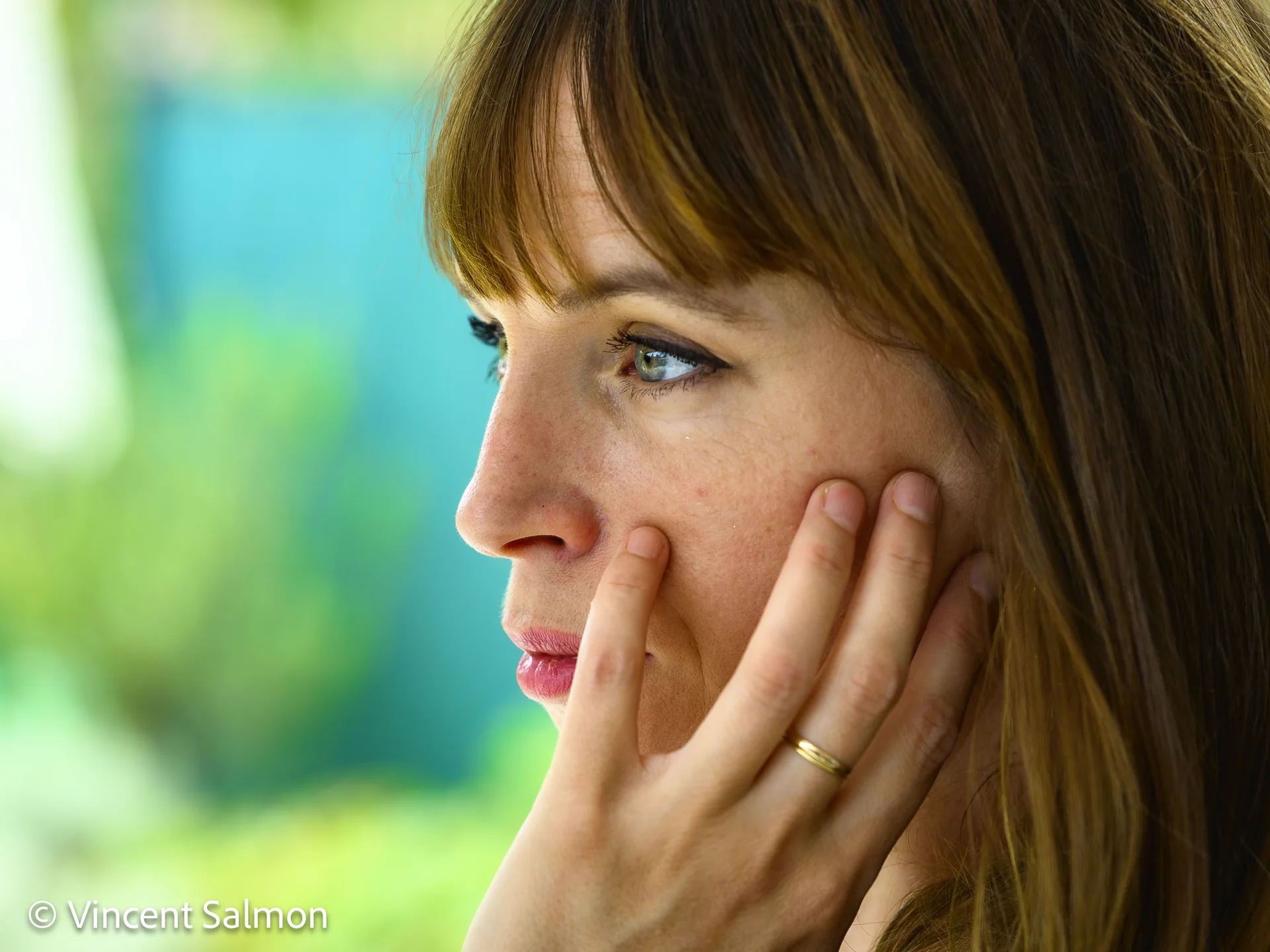 Photo de Vincent Salmon : profil d’une femme, la main contre la joue, en couleur