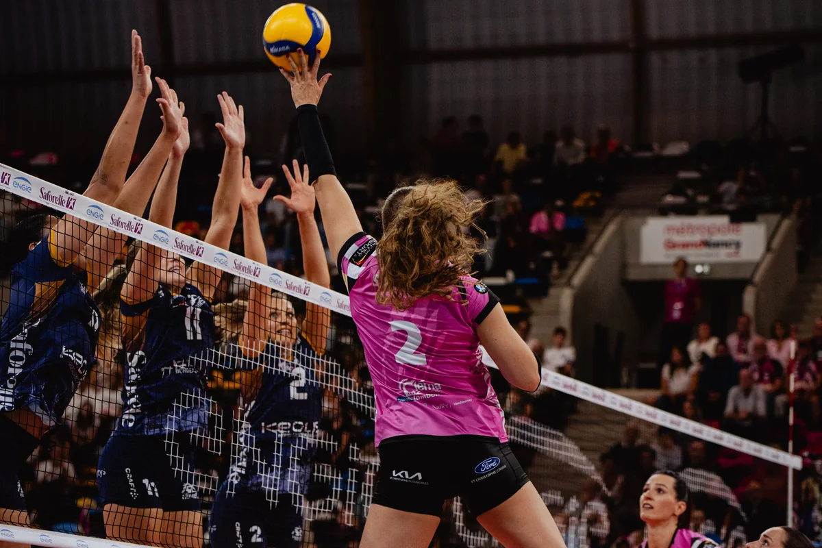 Une joueuse du Vandœuvre Nancy Volley-Ball en maillot rose attaque au filet